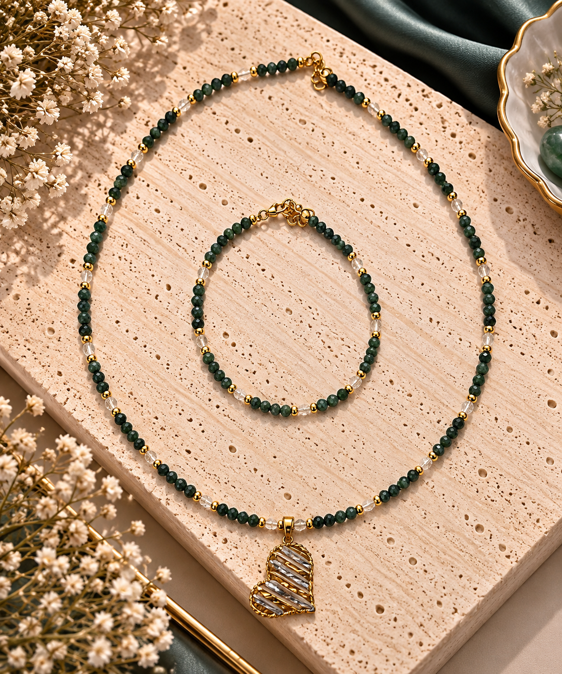 Parure collier et bracelet en perles facettees de tourmaline elbaite vert foret, billes cristal et separateurs dores avec pendentif coeur dore ajoure tresse