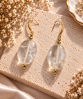 Boucles d'oreilles pendantes galets ovales polis en cristal de roche transparent veines sur crochets dores avec billes separatrices dorees