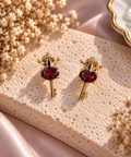 Boucles d'oreilles puces cabochons ovales facettes de pyrope rouge sang intense serties dans un motif cle couronnee doree ciselee