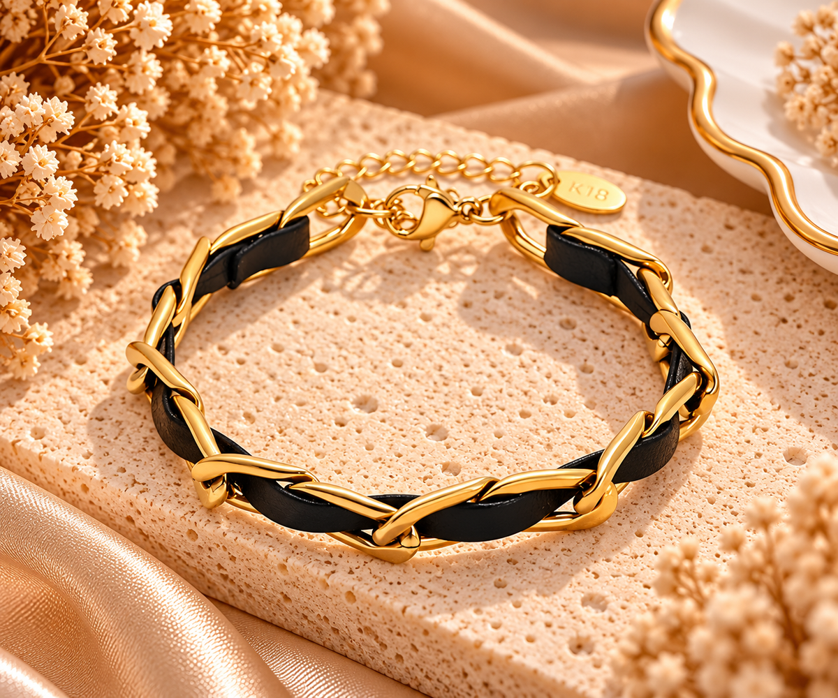 Bracelet Nocturne à maillons dorés allongés entrelacés d’une bande noire, avec fermoir mousqueton et chaînette d’extension