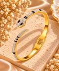 Bracelet jonc serpent doré orné de pierres transparentes et de détails noirs, avec tête et queue se faisant face
